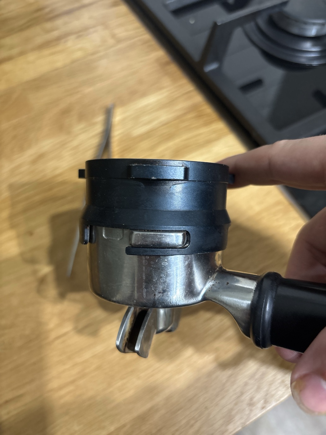 The black dosing ring clipped onto the portafilter, one ear visible through its slot
