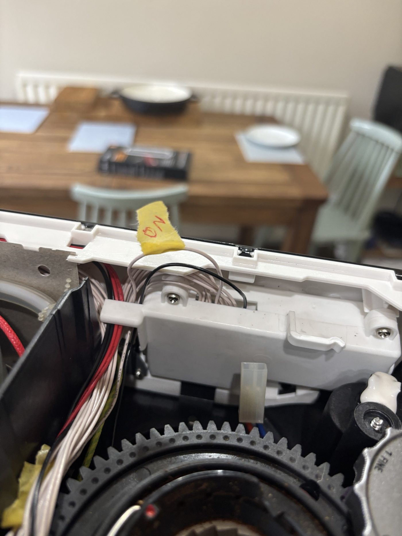 Behind the panel carrier, the white ON wire tagged and the black wire beside it